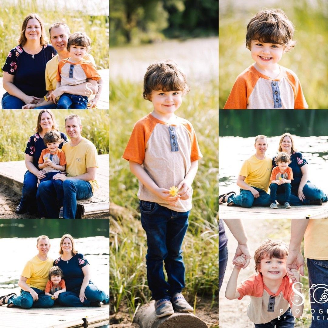 Family of three poses outdoors: boy in orange shirt, parents in blue and yellow, smiling.