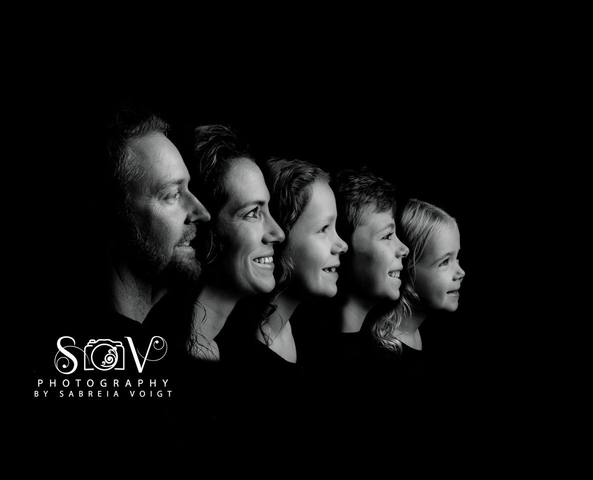 Family in profile, faces overlapping, smiling, against a black background.