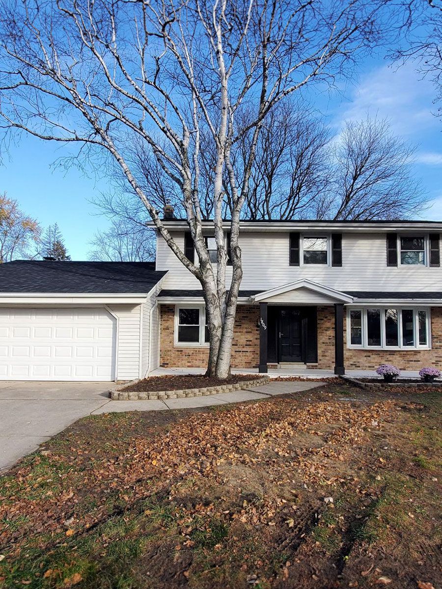 A large house with a tree in front of it.