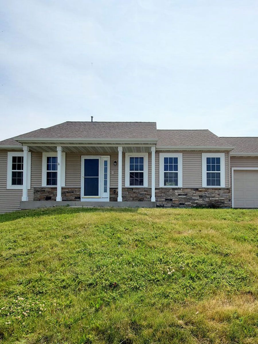A house with a large lawn in front of it.