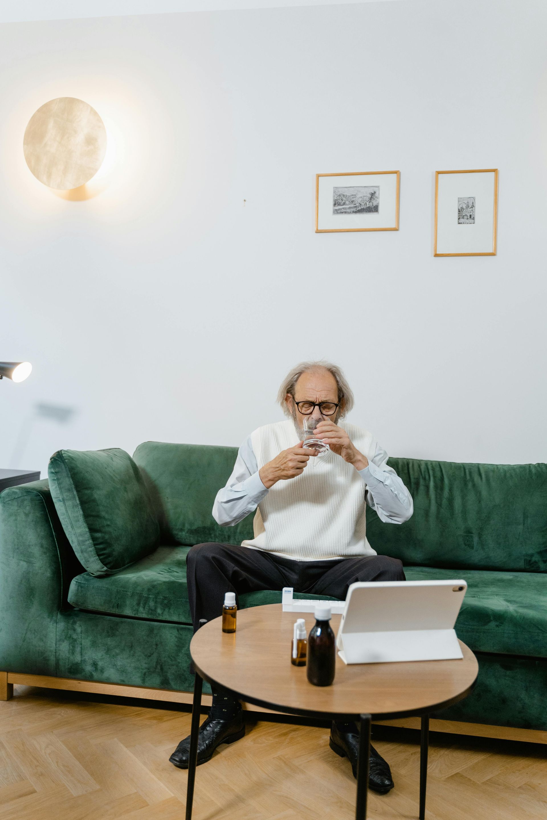An elderly couple is sitting on a couch talking to a man in a suit.
