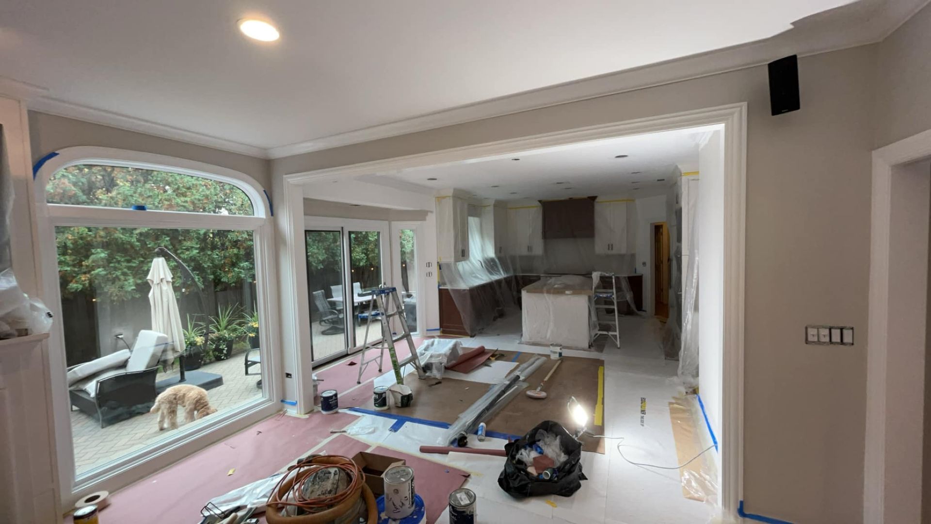 Kitchen remodel in progress with tools and materials scattered. Interior view, neutral colors.