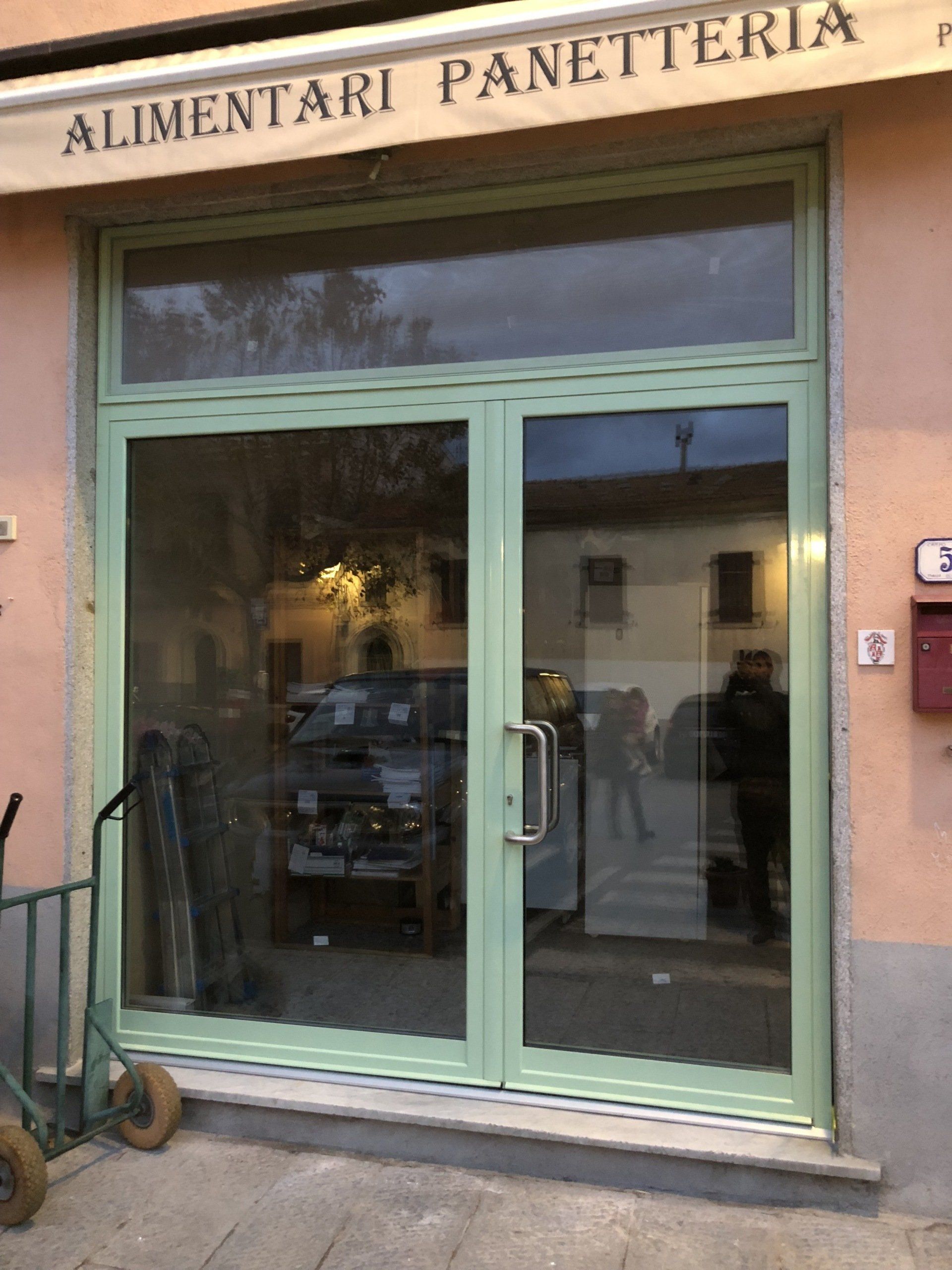 Vetrina con cornice verde e doppie porte in vetro; insegna 