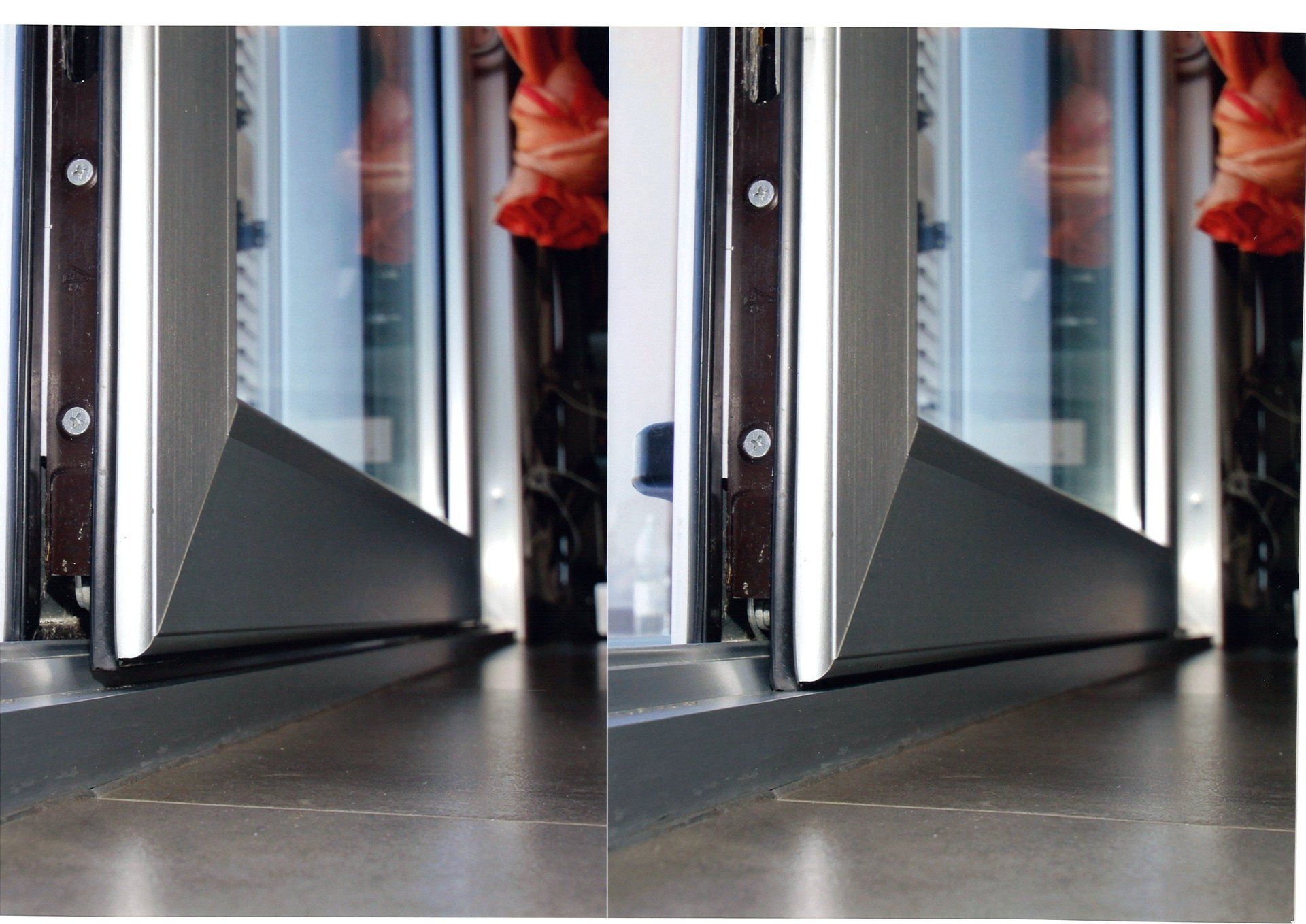 Primo piano del telaio di una finestra con finiture grigio scuro. La finestra è parzialmente aperta.