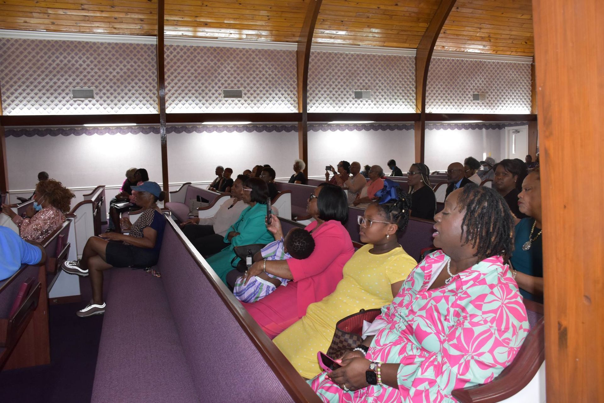 A group of people are sitting in a church watching a presentation.