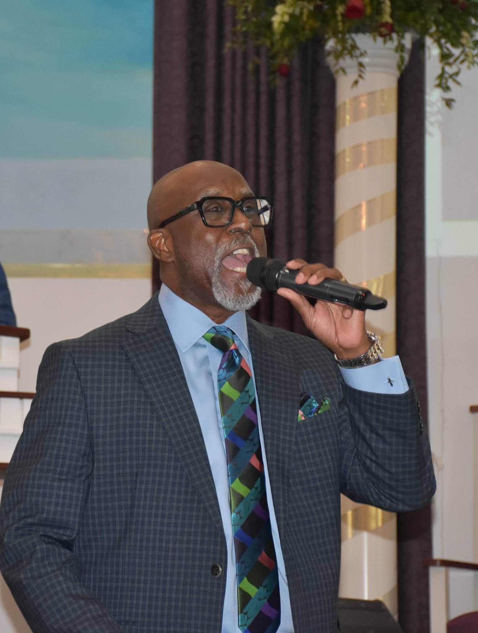 A man in a suit and tie is singing into a microphone