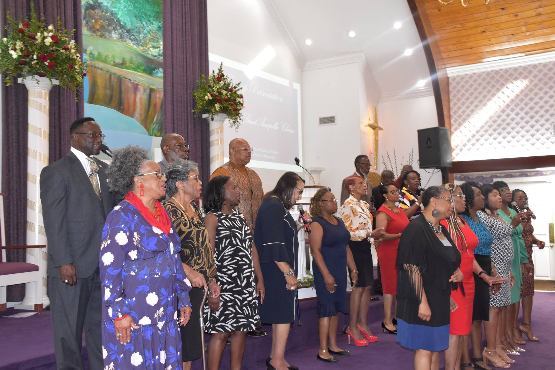 A group of people wearing face masks are posing for a picture in a room.