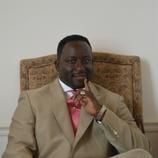 A man in a suit and tie is sitting in a chair.