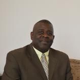 A man in a suit and tie is sitting on a couch.