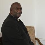 A man in a suit and tie is sitting in a chair.