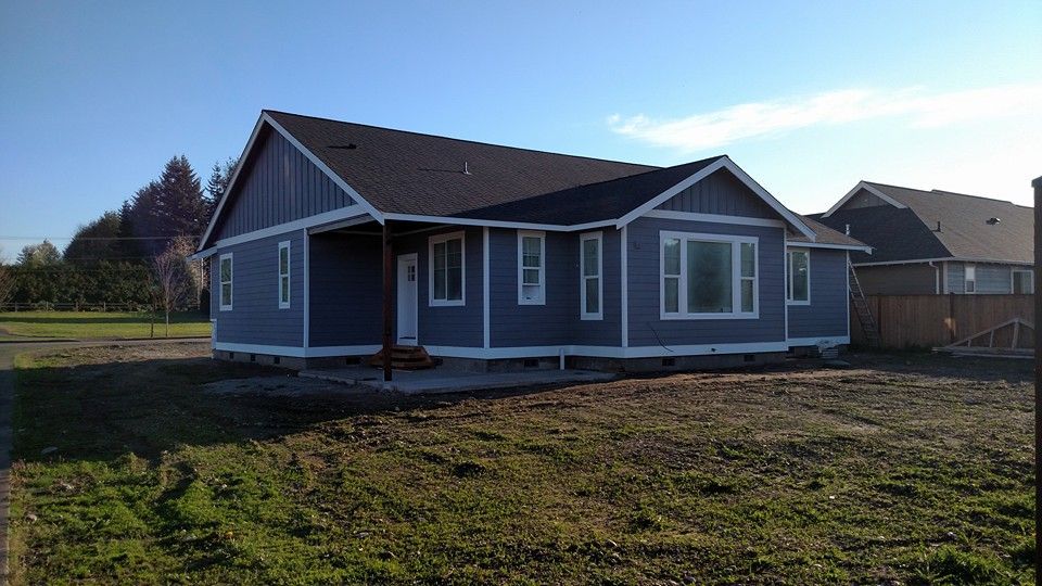 A house is sitting in the middle of a grassy field.