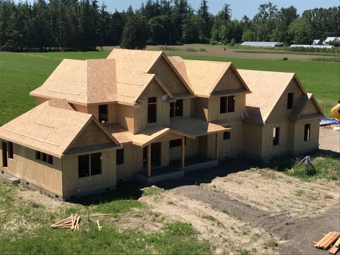 A large house that is being built in a field