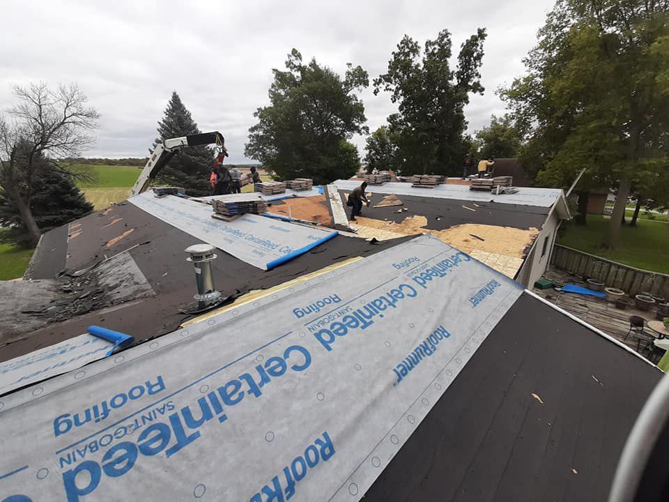 A roof is being repaired with a sheet of certainfeed roofing paper.