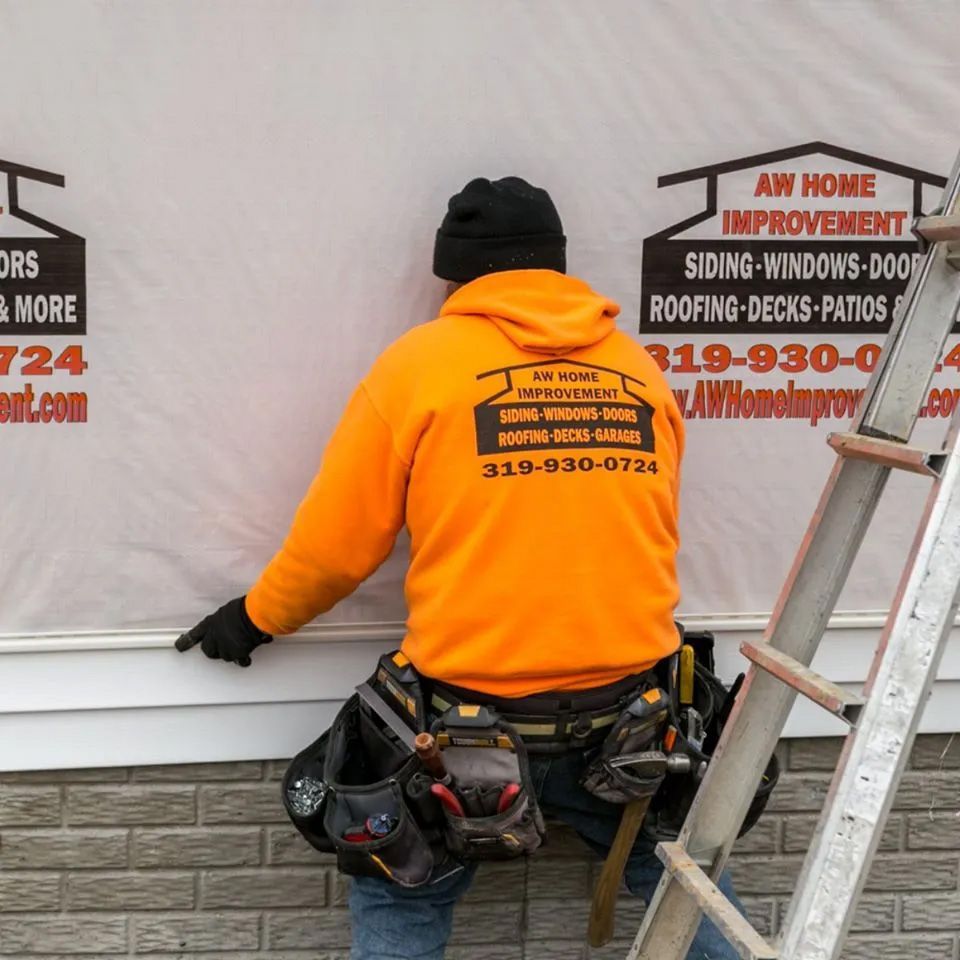 A man wearing an orange hoodie with aw home improvement written on the back