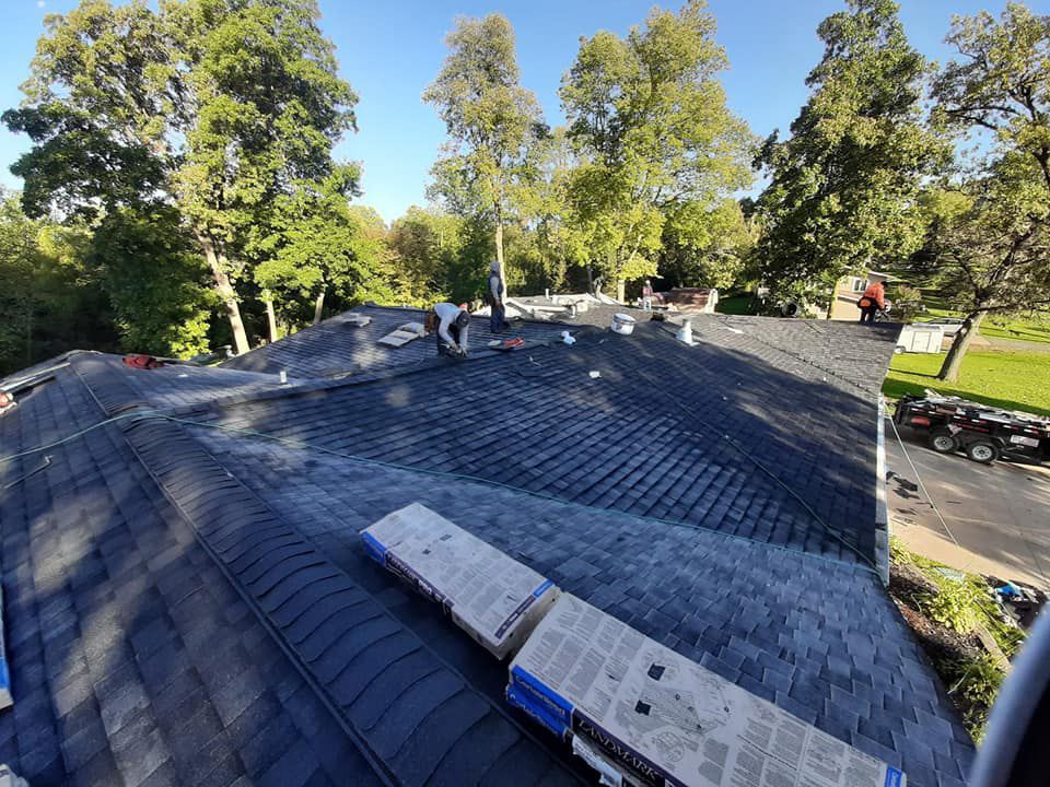 A man is working on the roof of a house.