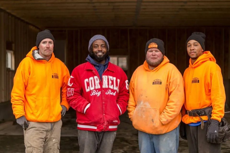 A group of men are standing next to each other in front of a building.