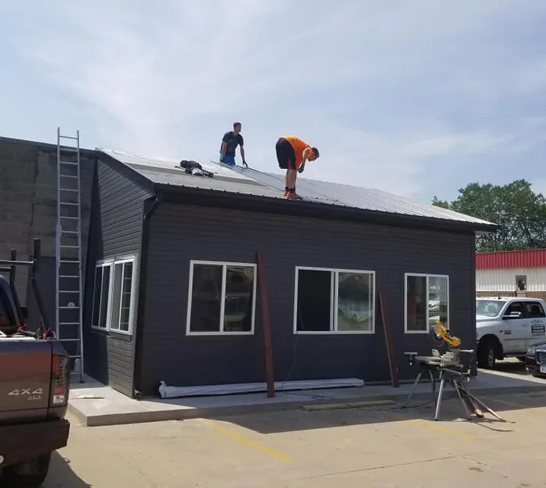 Two men are working on the roof of a building