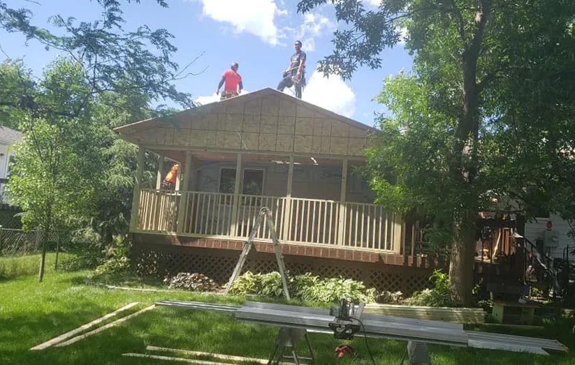 Two men are working on the roof of a house