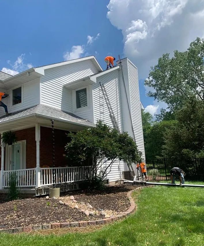Two men are painting the roof of a house.