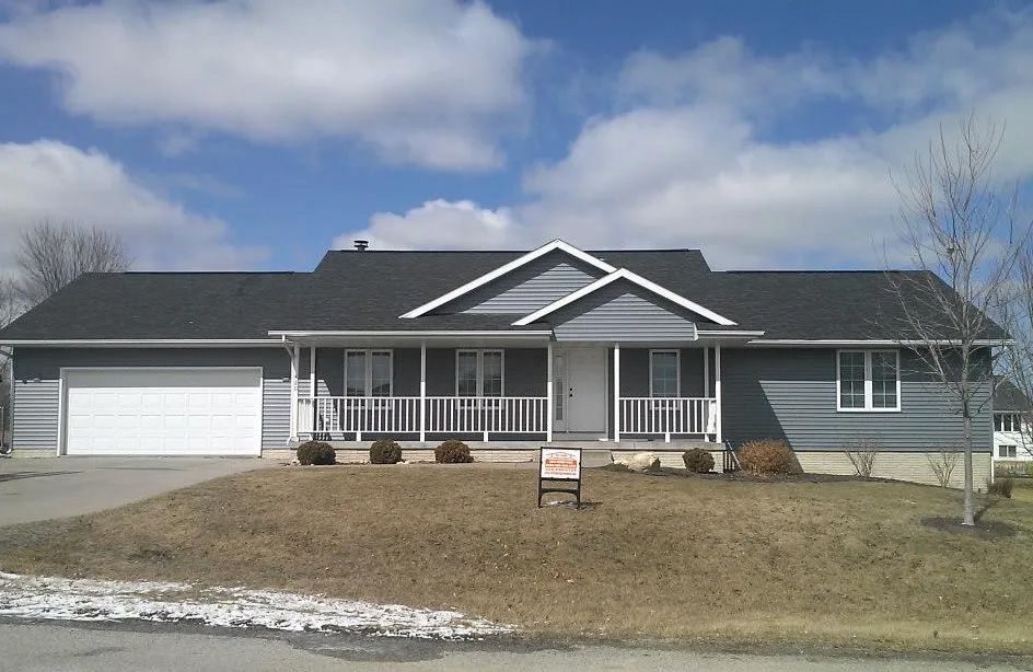 A house with a for sale sign in front of it