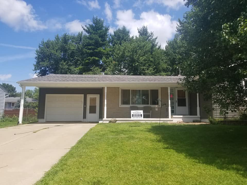 A house with a garage and a porch on a sunny day