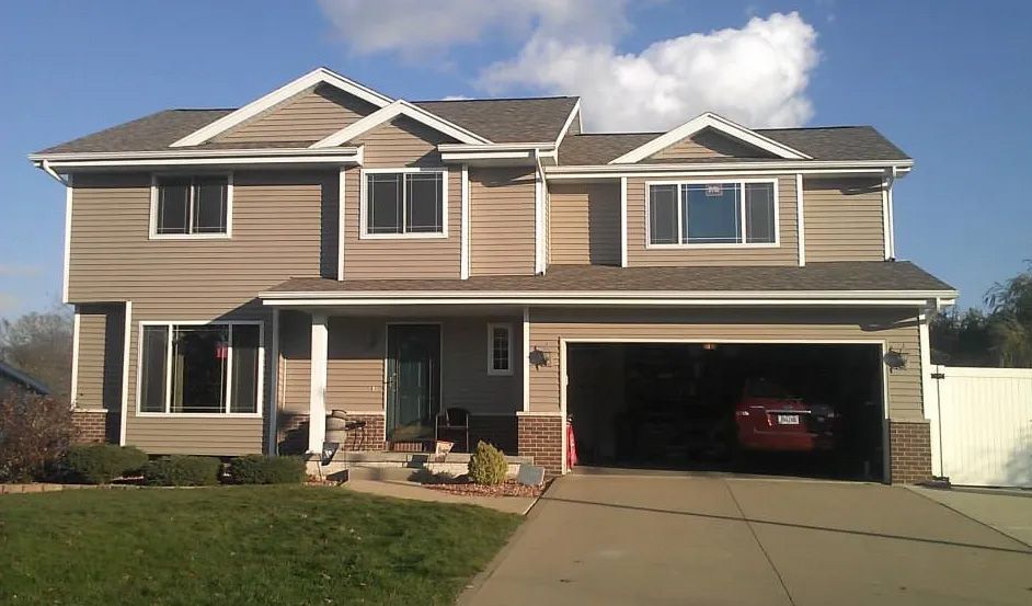 A large house with a car parked in the garage
