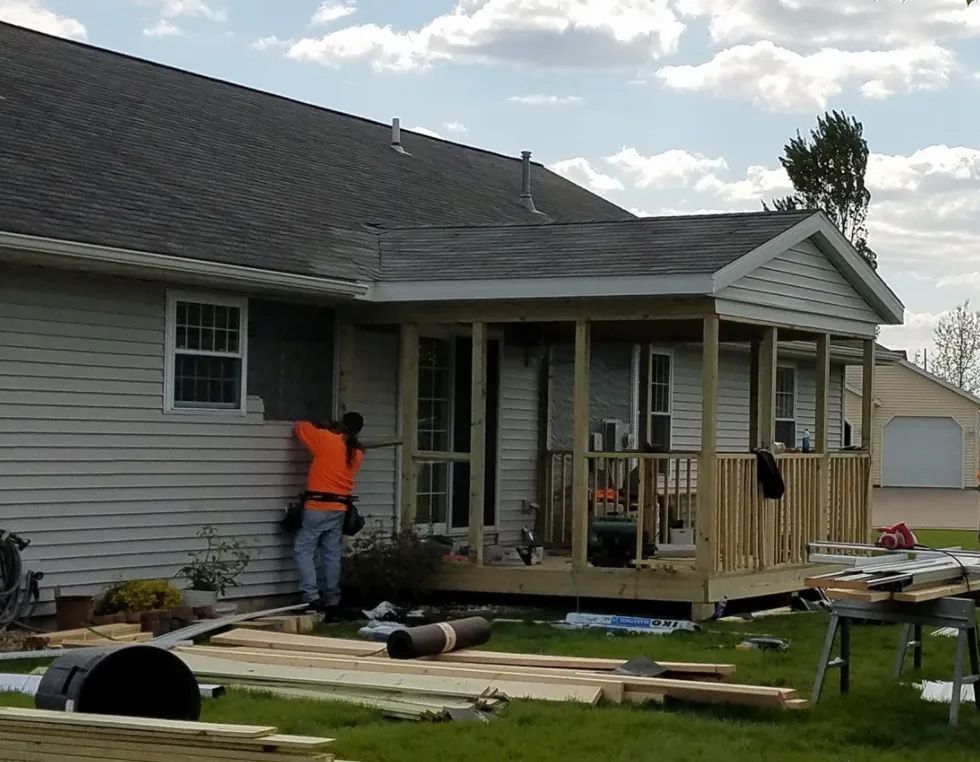A man is working on the side of a house