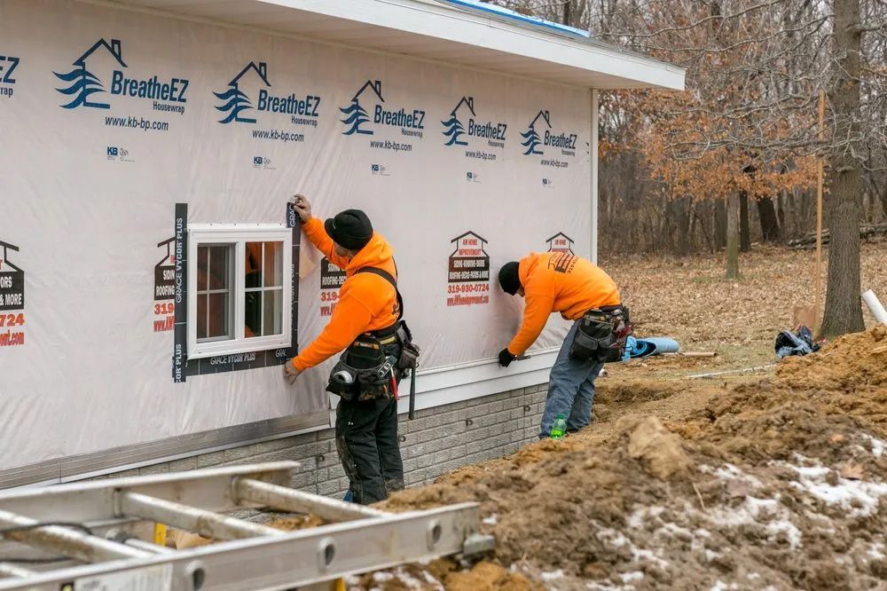 Two men are installing a window on the side of a building.