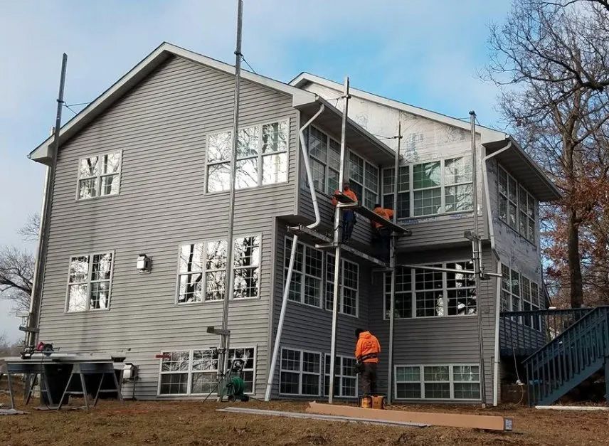 A large house with a lot of windows is being remodeled