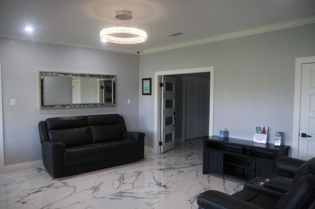 A living room with a couch , chair , and television.