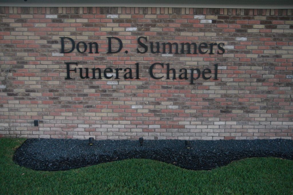 A brick wall with a sign that says don d. summers funeral chapel