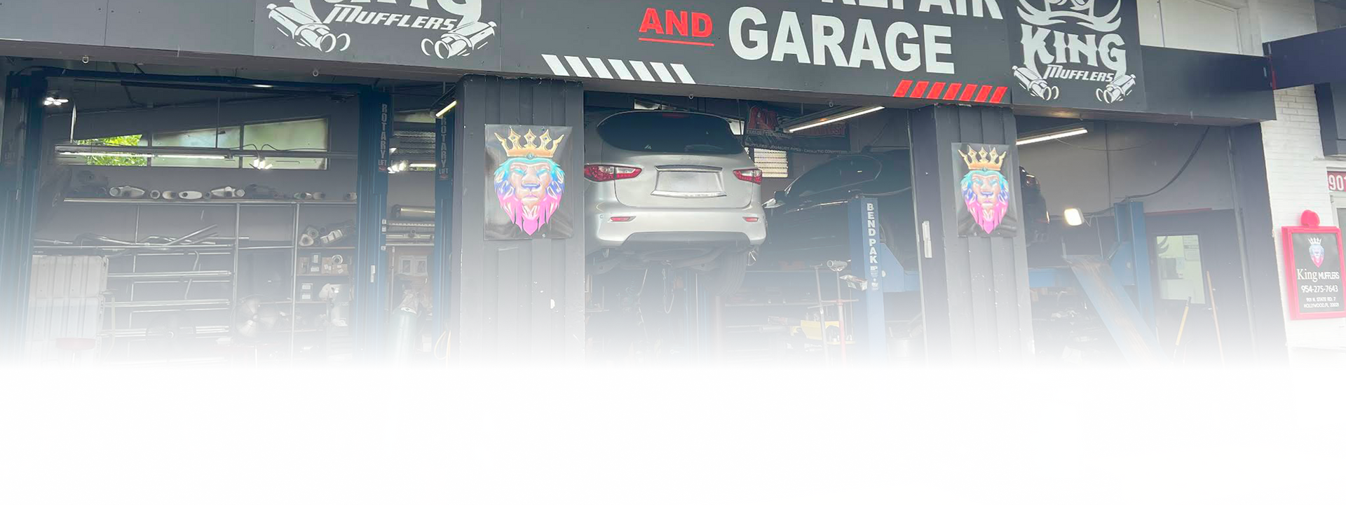 Auto repair garage with a car raised on a lift. | King Mufflers