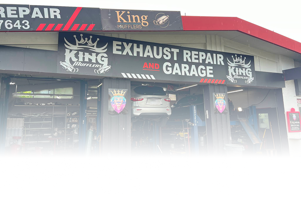 King Exhaust Repair and Garage: shop exterior, car on a lift, sign above doorway. | King Mufflers