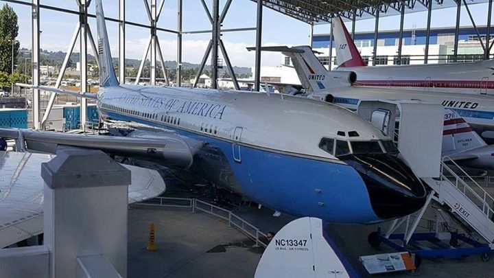 A blue and white airplane is parked in a hangar.
