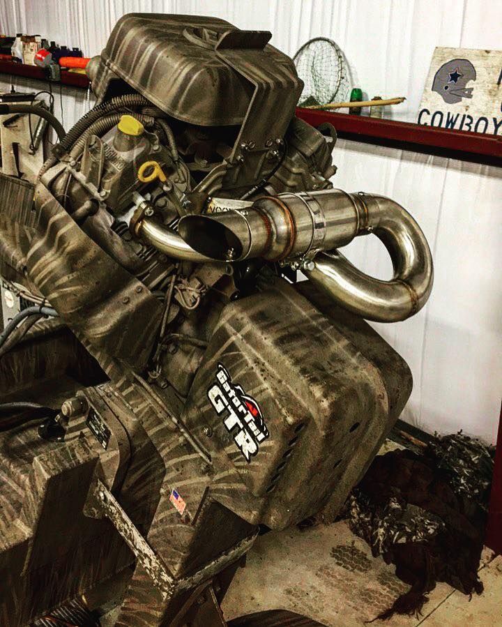 Mud-covered Gator-Tail GTR mud motor engine with a custom exhaust. Indoors.