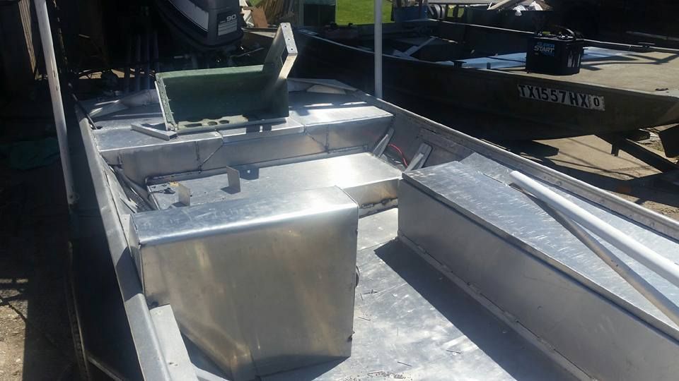 Interior of a metal boat with a seat, looking forward toward the bow.