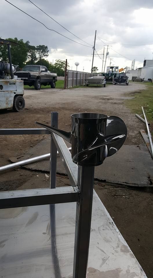 A black propeller attached to a metal post, with a blurred outdoor setting in the background.