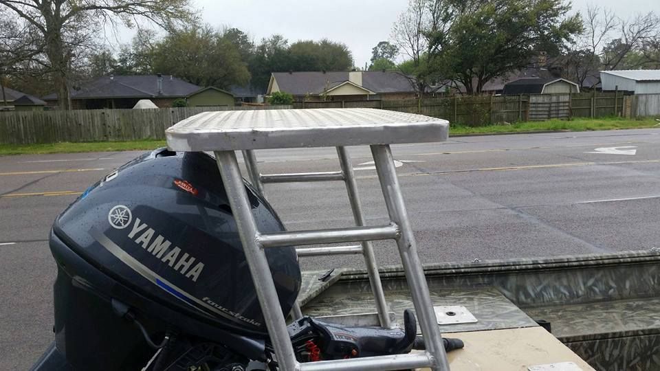Aluminum boat platform with Yamaha motor, on the road in front of houses.