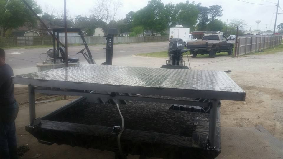Flatbed truck with diamond plate bed; outdoors. A person stands nearby.