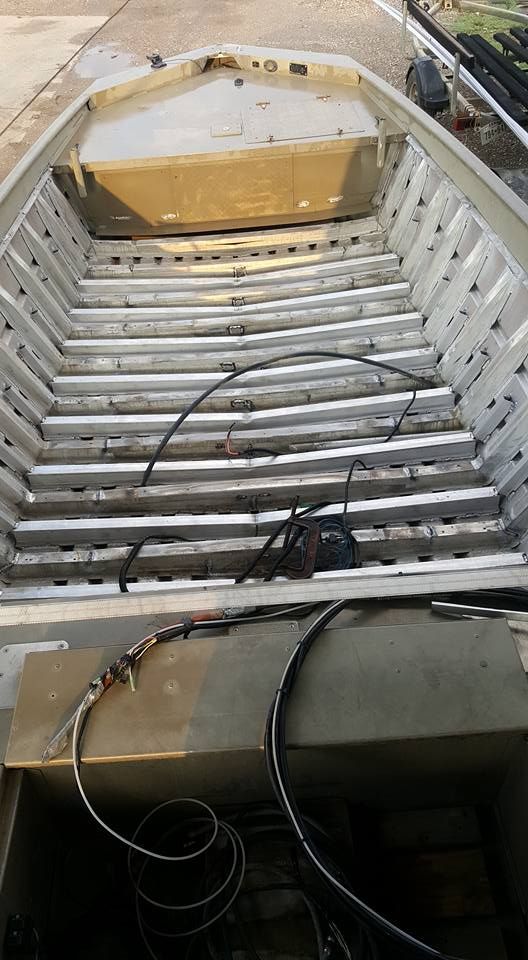 Aluminum jon boat interior showing ribs and storage compartments.