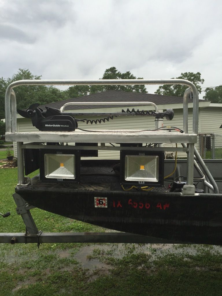 Boat with floodlights and metal railing, parked outdoors on trailer.