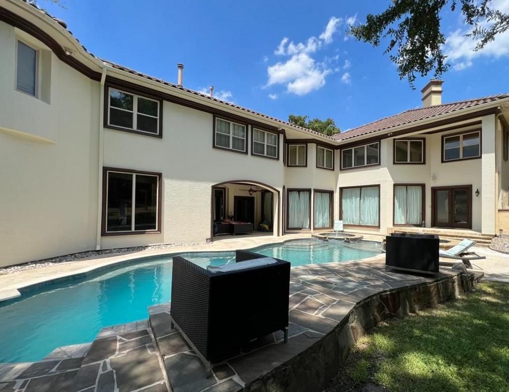 A large white house with a swimming pool in the backyard