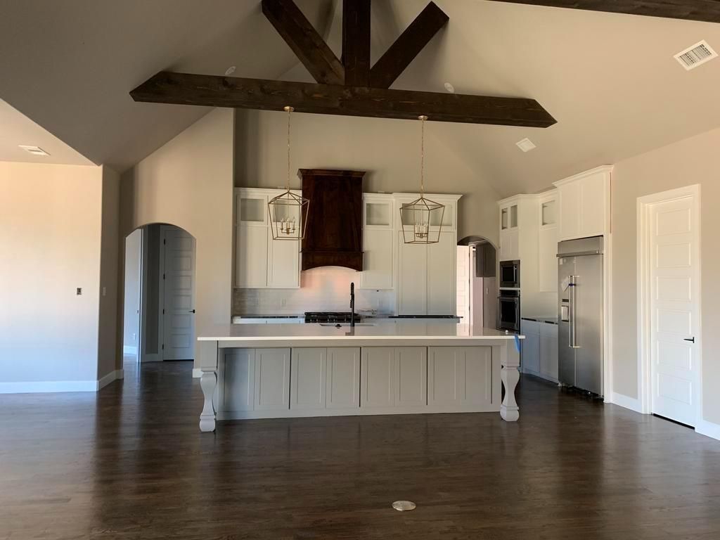 An empty kitchen with a large island in the middle of the room.