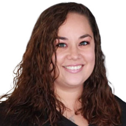 Woman with curly brown hair smiling.