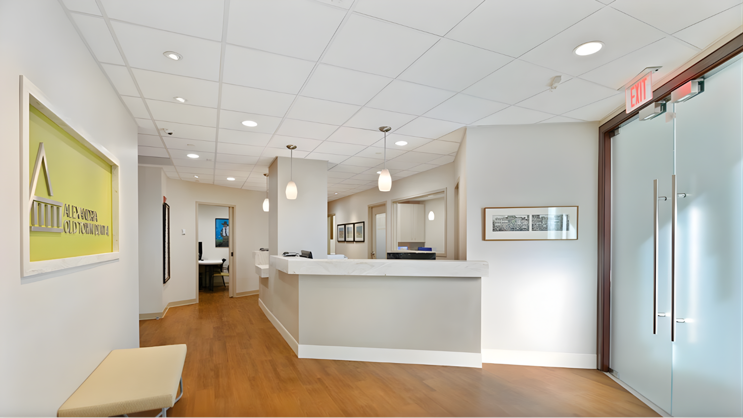 Reception area with a light-colored reception desk, art, and a waiting area.