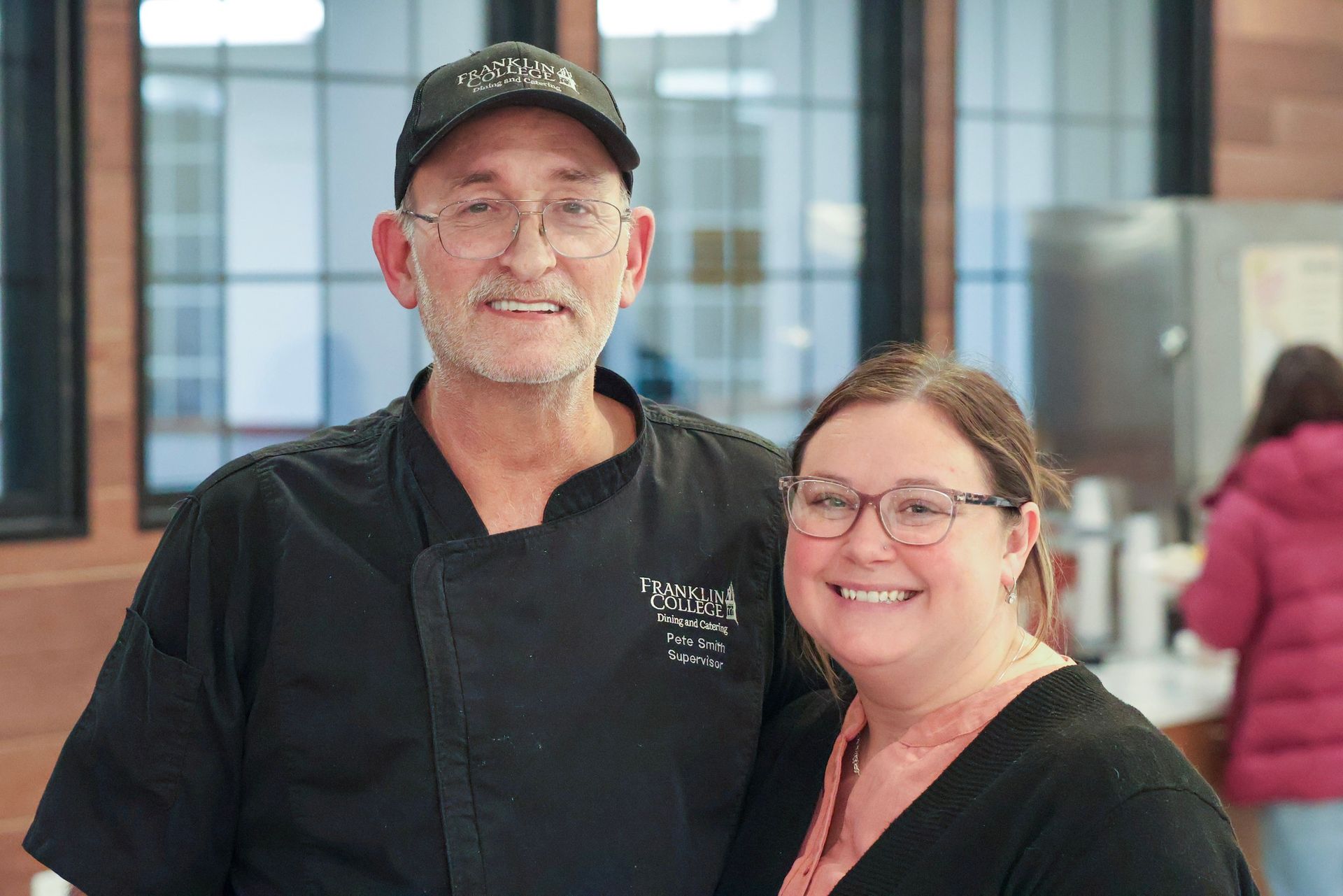 A man in a chef 's hat is posing for a picture with two other chefs