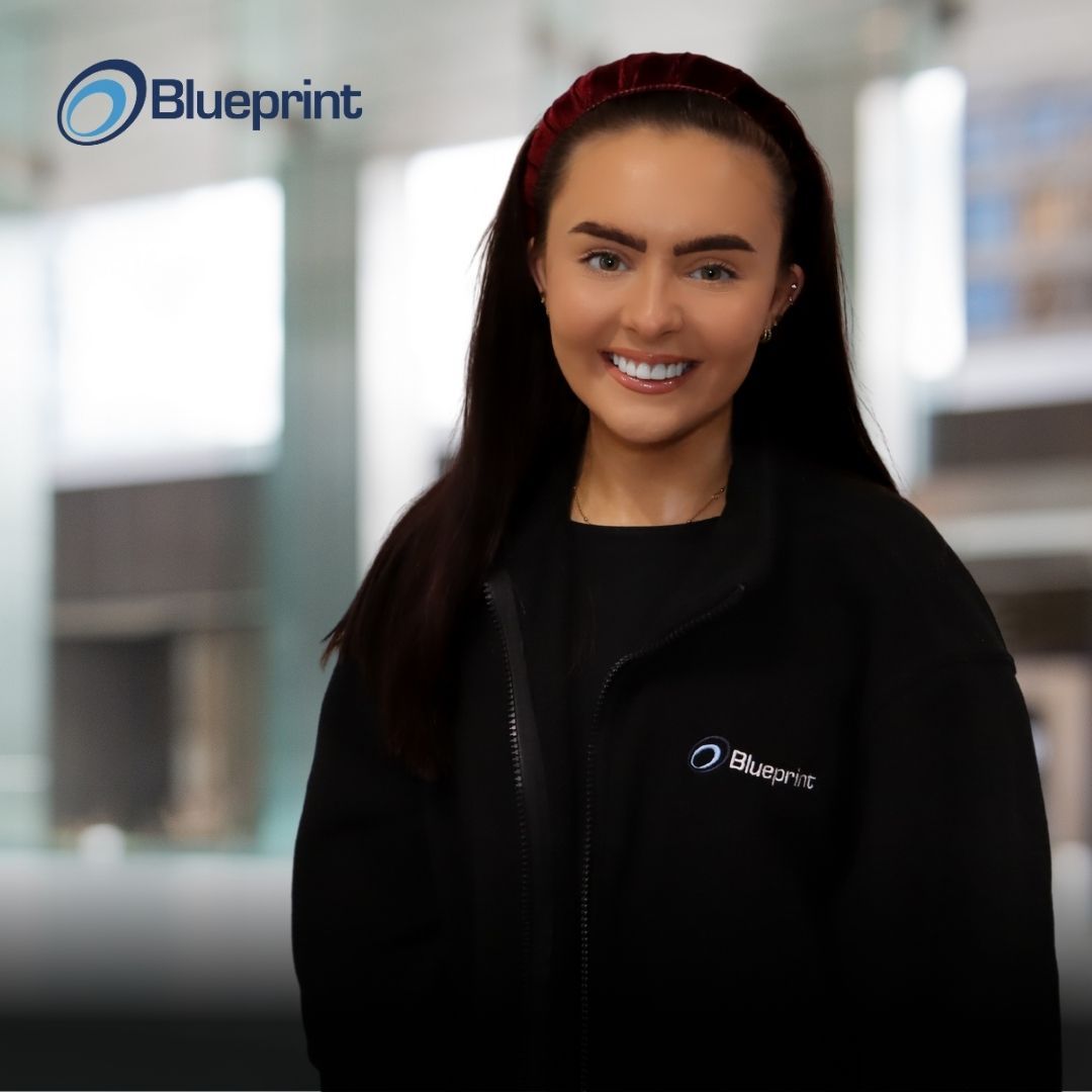 A woman wearing a black jacket with the word blueprint on it