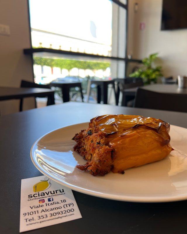 Un dolce su un piatto bianco con un biglietto da visita in un bar vicino a una finestra.