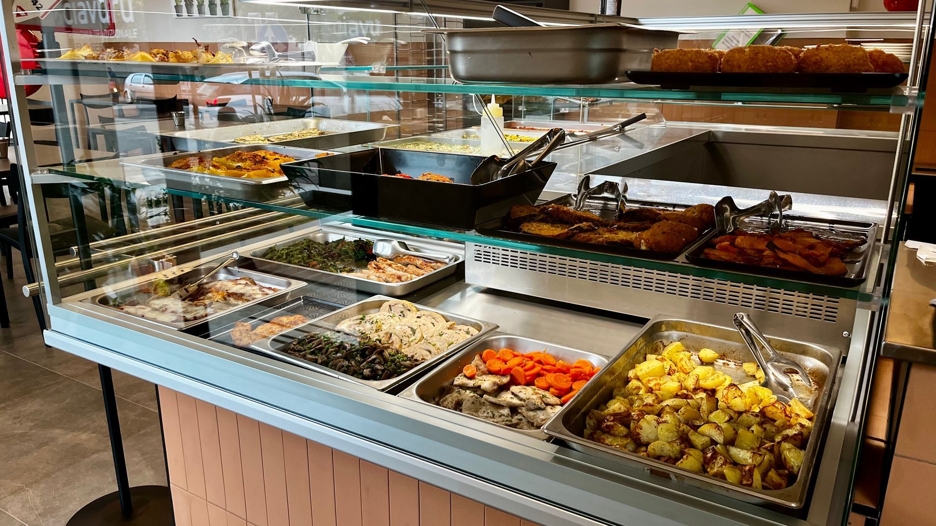 Un buffet con vari prodotti alimentari: verdure, carne e piatti al forno.