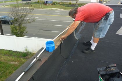 Worker Installing Roof Shingle — Island Park, NY — Eveready Roofing Co.